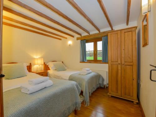 a bedroom with two beds and a window at Hook Cottage in Looe