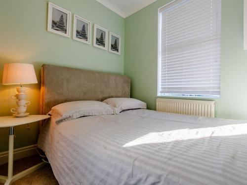 a bedroom with a bed and a table and a window at Relax In Ramsgate in Ramsgate