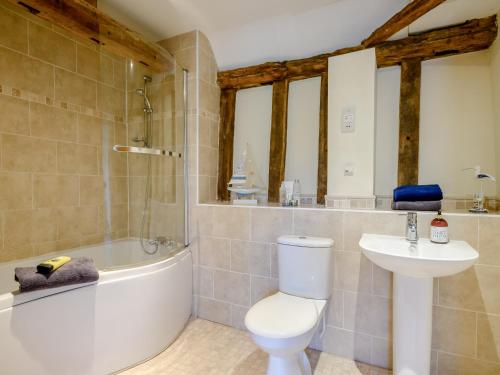 a bathroom with a tub and a toilet and a sink at Laurel Barn in Ashwellthorpe