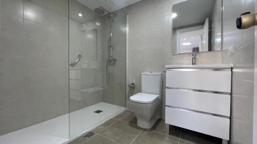 a bathroom with a toilet and a glass shower at benal beach 81 in Benalmádena