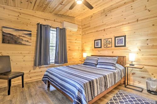 a bedroom with a bed in a log cabin at Quiet Pines Cabin with Hot Tub and Fishing Pond! in Logan
