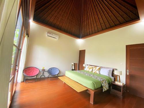 a bedroom with a bed and a wooden floor at Villa Mudha 3 Sanur in Sanur