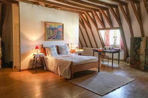 a bedroom with a bed and a table in a room at Charming 14th Century Village Chateau with gardens and outdoor pool in Celles