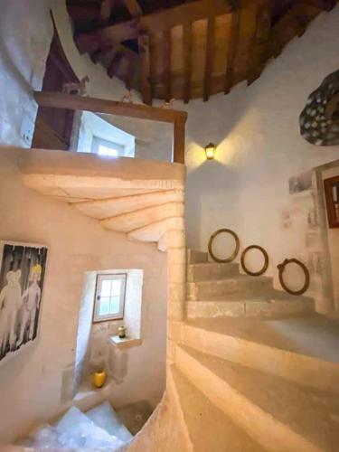 un escalier dans une maison avec de la neige sur les murs dans l'établissement Charming 14th Century Village Chateau with gardens and outdoor heated pool, à Celles