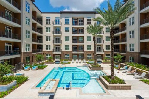an apartment building with a pool and palm trees at Apto 1 Bed - Kitchen - FREE Parking in Houston