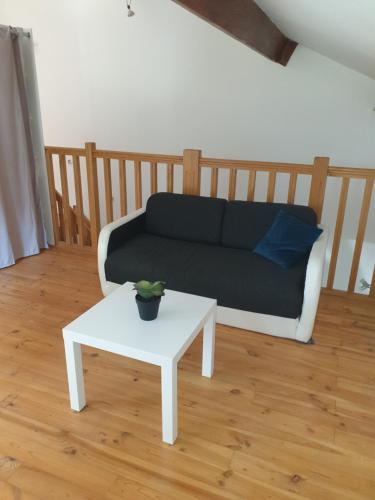 uma sala de estar com um sofá e uma mesa em Gîte l'olivier em Mézoargues