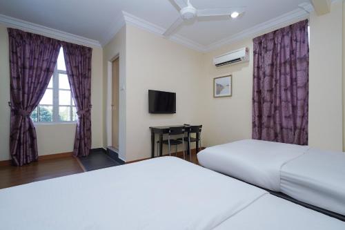a hotel room with two beds and a window at Super OYO 90009 Bangi Sri Minang Guesthouse in Bangi