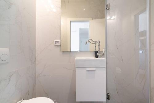 a bathroom with a toilet and a sink and a mirror at Decoreted 2 bed. Penthouse with a sun terrace in Tel Aviv
