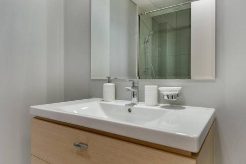 a bathroom with a white sink and a mirror at Bright and spacious apartment in DAMAC HILLS in Dubai
