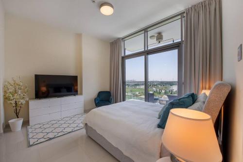 a bedroom with a large bed and a large window at Bright and spacious apartment in DAMAC HILLS in Dubai