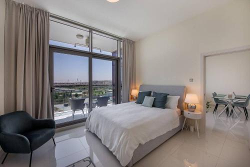 a bedroom with a bed and a large window at Bright and spacious apartment in DAMAC HILLS in Dubai