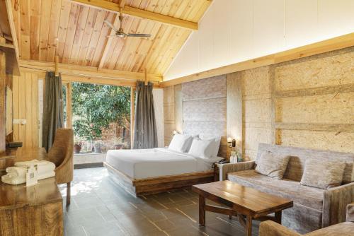 a bedroom with a bed and a couch and a table at The Sylvan Retreat in Dehradun