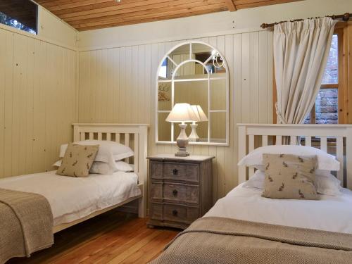 a bedroom with two beds and a table with a lamp at Pampita Lodge in Beverley