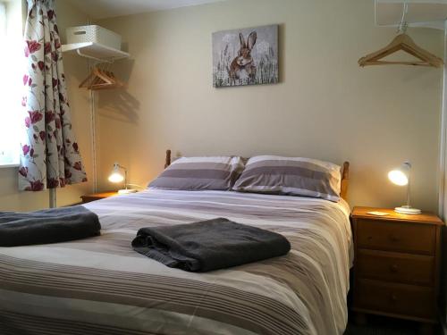 a bedroom with a bed with two towels on it at Bullrushes in Horning