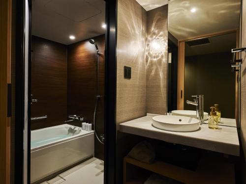 a bathroom with a sink and a bath tub at Asakusa View Hotel Annex Rokku in Tokyo