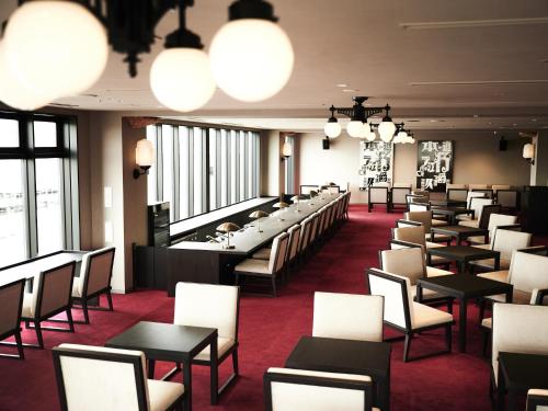 a row of tables and chairs in a room with windows at Asakusa View Hotel Annex Rokku in Tokyo