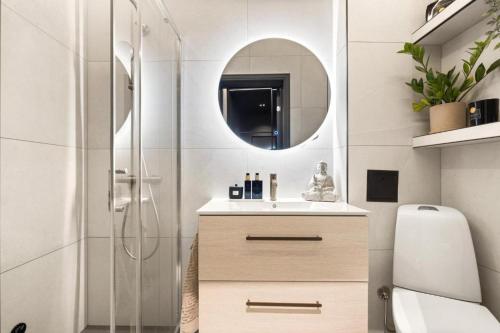 ein Bad mit einer Dusche, einem Waschbecken und einem Spiegel in der Unterkunft Majorstuen Apartments by Key Butler in Oslo