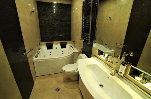 a bathroom with a tub and a toilet and a sink at Agava Tbilisi in Tbilisi City