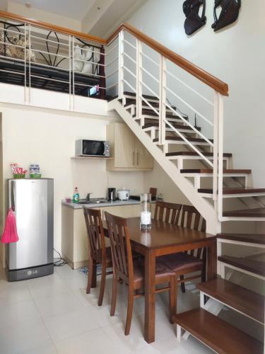 a kitchen with a dining room table and a staircase at Monteluce Staycation in Silang