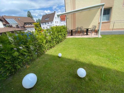 three white balls sitting on the grass in a yard at Gästehaus am Kurpark Hotel Garni in Horn-Bad Meinberg