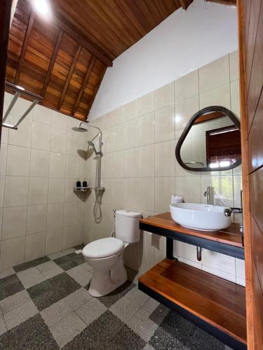 a bathroom with a toilet and a sink at dbelish village & resto in batumadeg