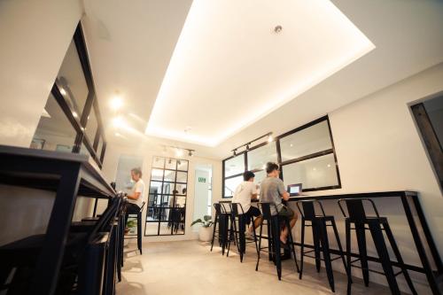 un grupo de personas sentadas en un bar en una habitación en Seeya Hotel en Tubigon