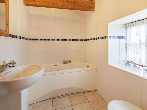 a bathroom with a tub and a sink and a bath tub at The Parlour - Uk37517 in Routh