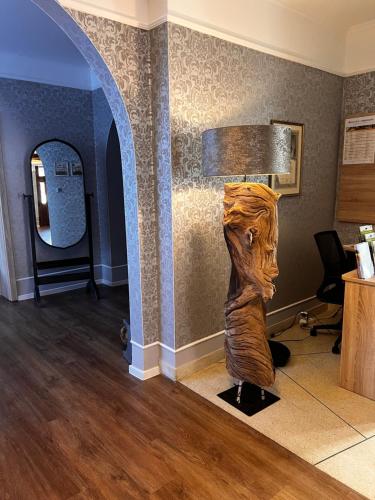 a wooden statue in a room with a lamp at Gästehaus am Kurpark Hotel Garni in Horn-Bad Meinberg