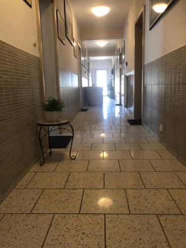a hallway with a tile floor and a table in a building at Ubytování U draka in Třeboň