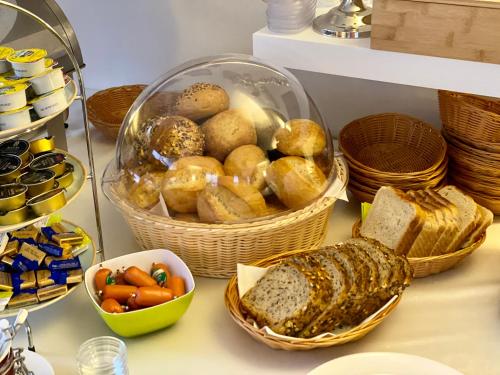 a table with baskets of bread and baskets of food at Gästehaus am Kurpark Hotel Garni in Horn-Bad Meinberg