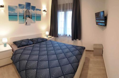 1 dormitorio con 1 cama con edredón azul y ventana en EL BOBO BEACH- Deluxe 2 bedroom apartment, en Playa Fañabe