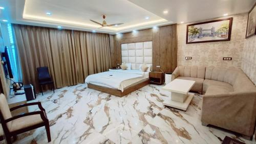 una camera da letto con pavimento in marmo, letto e divano di V SQUARE AIRPORT HOTEL a Lucknow