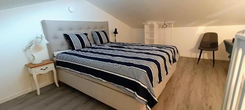 a bedroom with a bed with a black and white striped blanket at Sparkling modern house in Kista - close to city in Stockholm