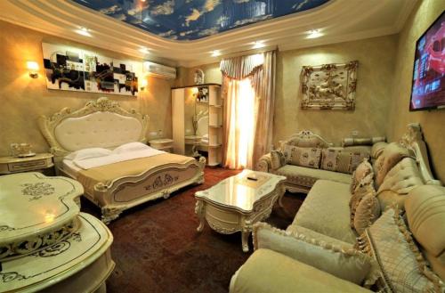 a bedroom with two beds and a couch and a table at Agava Tbilisi in Tbilisi City