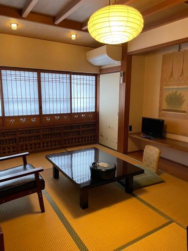 a living room with a coffee table and a couch at Sangai Ryokan in Gotsu