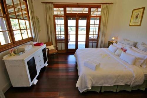 a bedroom with a large white bed and a television at Hanging Tree Wines in Pokolbin