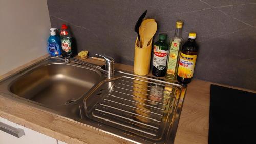 a kitchen sink with bottles and a rack next to it at RYE Ferienwohnung Hamburg in Hamburg