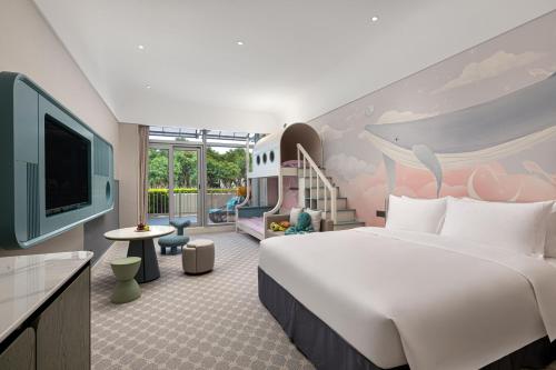 a hotel room with a large bed and a tv at Xiamen International Seaside Hotel -Hotel corridor leads to the stone exhibition hall in Xiamen