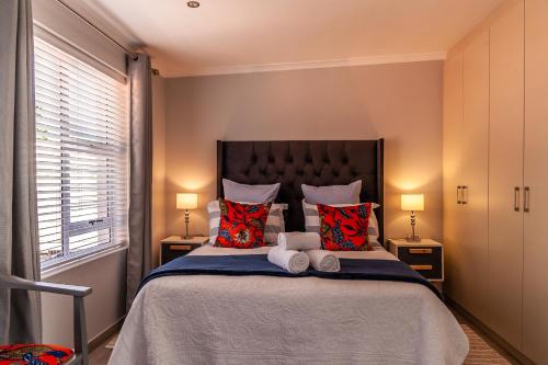 um quarto com uma cama grande e 2 candeeiros em Tortelduif Cottage em Stellenbosch