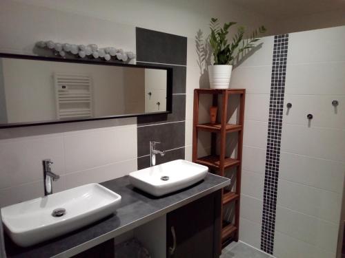 een badkamer met een wastafel en een spiegel bij Gites Le Pressoir in Vias