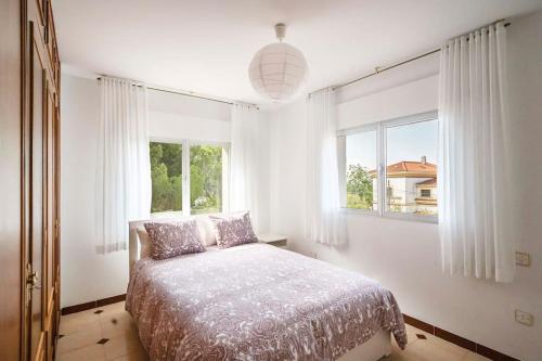 a bedroom with a bed and a large window at Casa Hortensia. Barbacoa en Robledo de Chavela in La Estación