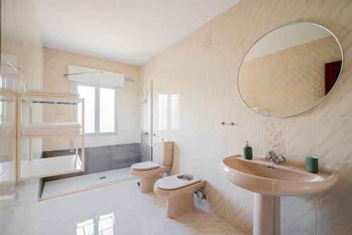 a bathroom with a sink and a toilet and a mirror at Casa Hortensia. Barbacoa en Robledo de Chavela in La Estación