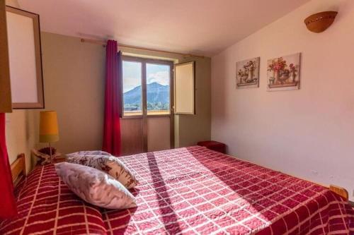 een slaapkamer met een bed met een rode deken en een raam bij Holiday home in Francavilla di Sicilia in Francavilla di Sicilia