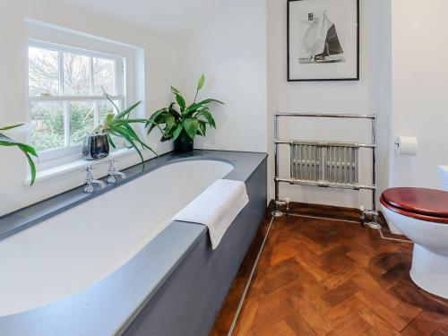 a bathroom with a large tub and a toilet at Anchor Light Cottage in Faversham