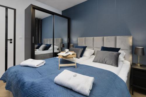 a bedroom with a large bed and a mirror at Apartments Beaufort Estate by Renters in Gdynia