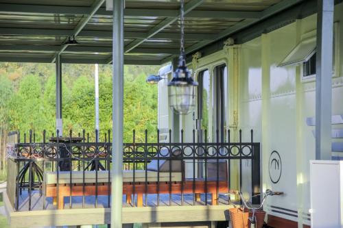 a porch with a table and a chandelier at Nex Station Kanchanaburi in Kanchanaburi