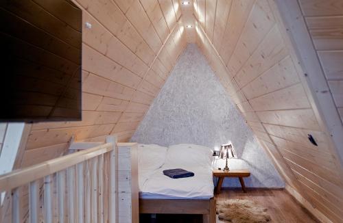 un lit dans une chambre avec un plafond en bois dans l'établissement Reglove luksusowe apartamenty, à Zakopane