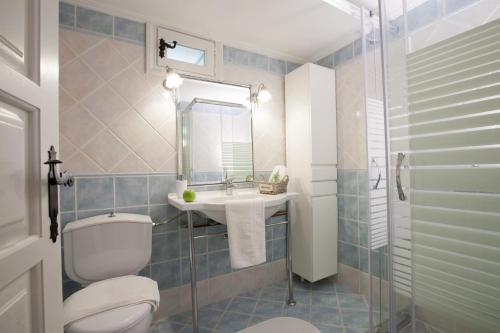 bagno con servizi igienici, lavandino e specchio di Villagio Magnolia a Sívros