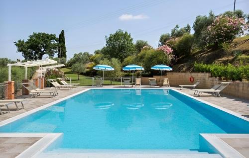 a swimming pool with chairs and umbrellas at Agriturismo Casale Giulia in Volterra