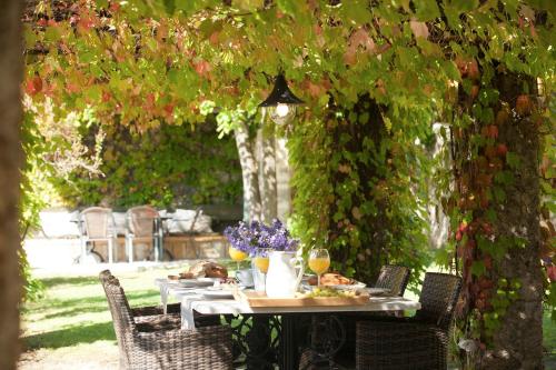 a table with food and drinks on it under a pergola at Villagio Magnolia in Sívros